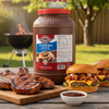 Jar of American Select Hickory BBQ Sauce with grilled chicken, burgers, and sauce on a wooden board outdoors.